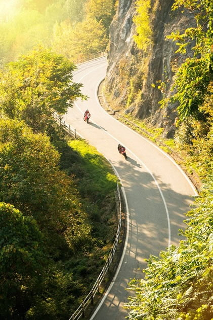 two motorcycles riding on a curvy mountain road